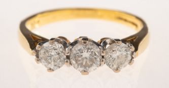 An 18ct gold three stone diamond ring, claw set with three brilliant-cut diamonds, diamonds approx.