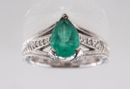 An emerald and diamond ring, of Art Deco style, claw set to the centre with a pear-shaped emerald,
