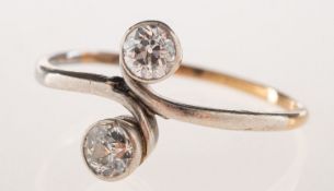 A diamond 'toi et moi' ring, collet set in a twist setting with two old-cut diamonds,