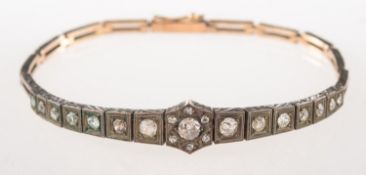 An Art Deco diamond bracelet, an ornate bi-metal articulated link Art Deco bracelet,