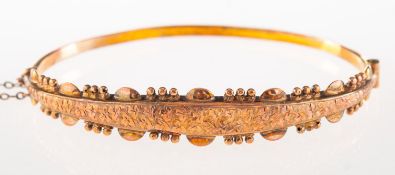 Smith & Pepper - A 9ct gold early 20th century bangle,