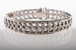 A diamond line bracelet, an articulated bracelet of openwork foliate design links,