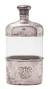A silver mounted clear cut-glass spirit flask, oval form, with a pull-off cup & cover,