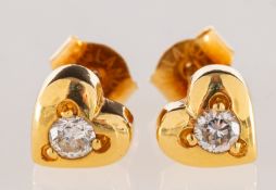 A pair of diamond heart shaped studs, each grain set to the centre with a brilliant-cut diamond,