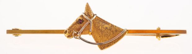 A horses head bar brooch, the textured finish horses head has a small red stone cabochon eye,