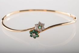 A diamond and emerald bangle,