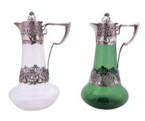 Two Edwardian Art-Nouveau silver mounted glass claret jugs, tapering form with spreading bases,