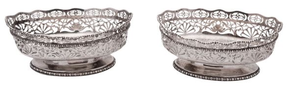 A pair of early 20th century silver bonbon dishes, shaped oval outline, with bead borders,