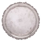 A George V silver salver, of shaped circular outline, with a husk & scroll border and on three legs,