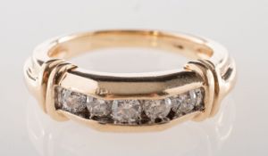 A five stone diamond ring, channel set in a semi-hexagonal setting with five brilliant-cut diamonds,