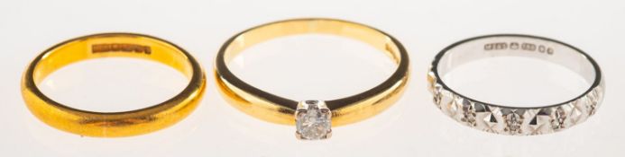 A group of three rings, including a 22ct gold wedding band, UK hallmark, size L, 4.