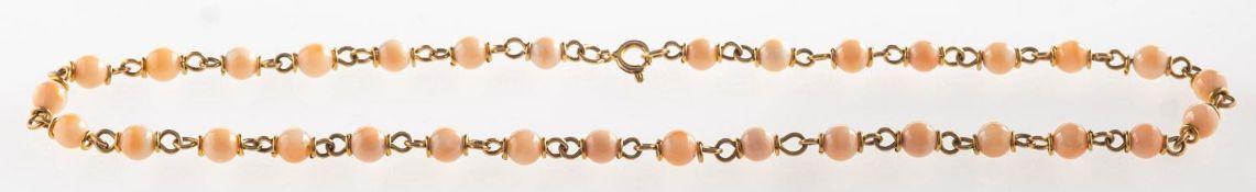 A coral and chain link necklace, a necklace of alternating coral beads and chain links,