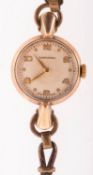 Longines a 1950s gold lady's wristwatch the round cream dial having raised Arabic & dot numerals,