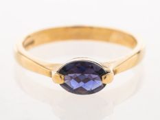 A 9ct gold iolite ring, set east to west with an oval mixed-cut iolite, UK hallmark, size M, 2.