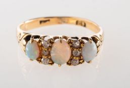 An antique opal and diamond ring, set with three oval opal cabochons,