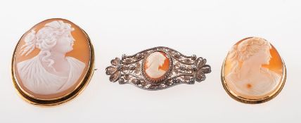 A group of three cameo brooches, including a large cameo in a plain mount, (dented in places),