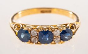 A sapphire and diamond ring, set with three circular-cut sapphires,