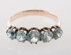 A five stone ring, claw set with five graduated blue stones,