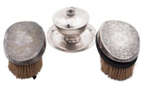 A George V silver table lighter, of circular form, with a twist-open cover and on three bun feet,