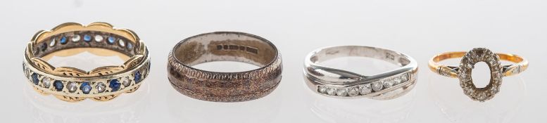 A group of four rings, including a crossover style ring set with cubic zirconia,