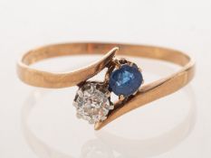 A diamond and sapphire 'toi et moi' ring, claw set in a twist setting with an old-cut diamond,