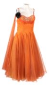 A group of four 1950/60's dresses, including an orange tulle mid-length dress with full skirt,