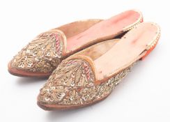 A pair of early 20th century red silk eastern (possibly Indian or Sri Lankan) slippers,