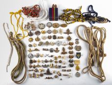 A collection of military and sporting related cap badges.