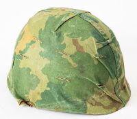 An American M1 steel helmet with cloth camouflage cover.