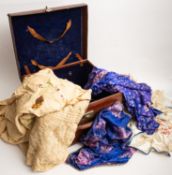 A mid 20th Century leather travel case containing various tablecloths,