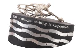 A scale model of the RNLI Memorial Sculpture showing a white metal figure in a boat saving another