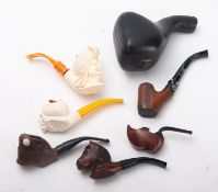 A carved walnut pipe in the form of a cow, the bowl flanked by two horns on an ebonised stem,