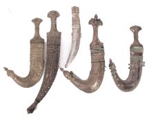 Five white metal Arabic daggers.