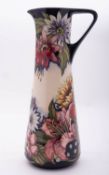 A Moorcroft pottery ewer of tapering form tube lined in the Sandbach Bouquet pattern after a design
