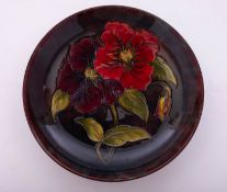 A Walter Moorcroft pottery shallow dish tube lined in the Anemone pattern on a flambé ground,