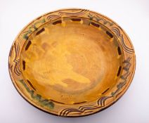 *Clive Bowen [b 1943] a large terracotta charger decorated with finger trails in mustard over brown