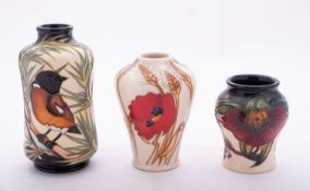 Three small Moorcroft pottery vases comprising a waisted vase tube lined in the wanderer pattern