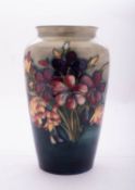 A Walter Moorcroft pottery vase of slender oviform tube lined in the Spring Flowers pattern