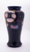 A Walter Moorcroft pottery vase of baluster form tube lined in the Pansies pattern
