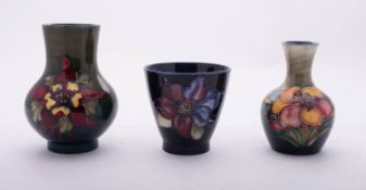 Three Walter Moorcroft pottery vases comprising a squat example tube lined in the Columbine pattern