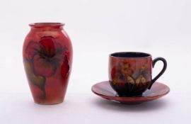 Three pieces of Walter Moorcroft pottery comprising a cup and saucer tube lined in the Orchid