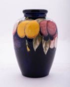 A William Moorcroft pottery vase, of oviform, tube lined in the Wisteria pattern on a blue ground,