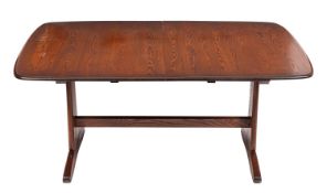 An Ercol dark elm extending dining table and six chairs en suite,