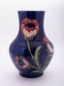 A William Moorcroft vase of baluster form tube lined in the Big Poppy pattern reserved on a blue