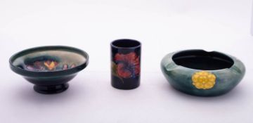 Three pieces of Walter Moorcroft pottery, comprising an ashtray tube lined with a rose,