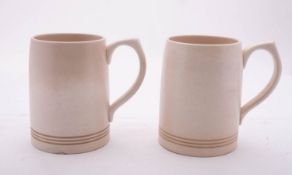 Keith Murray for Wedgwood, a pair of mugs under ivory glazes, printed marks, 13cm high,