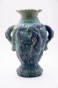 An art pottery vase moulded with fish under blue green glaze, 40cm high.
