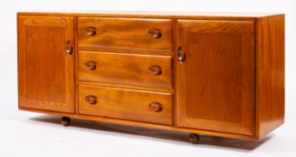 An Ercol 'Windsor; light elm sideboard, circa 1960s; with three drawers flanked by panel doors,