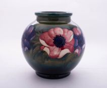 A Walter Moorcroft pottery vase of globular form tube lined in the Anemone pattern reserved on a