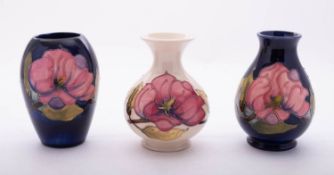 Three Moorcroft pottery vases each tube lined in the Magnolia pattern,